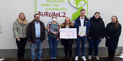 The apprentices hand over a donation check to the Bergisches Kinder- und Jugendhospiz