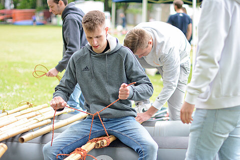 Apprentices building rafts