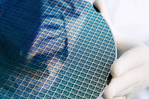 An employee handling a silicon wafer