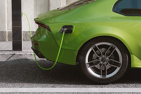 Coroflex Ladekabel verbunden mit Ladestation und grünem Fahrzeug