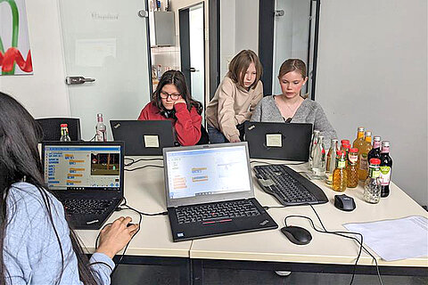 Four participants at laptops in the IT department
