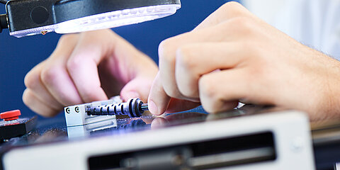 Hands of employees under lamp in laboratory